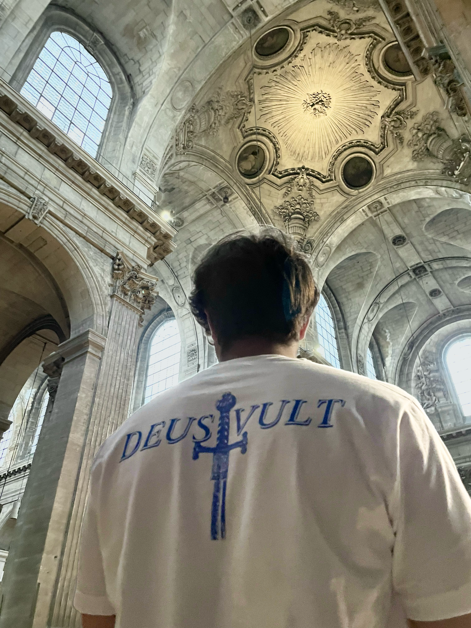 Personne portant un t-shirt « Deus Vult » à l’intérieur d’une grande cathédrale